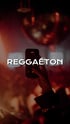 Eine Hand hält ein Smartphone hoch, das in einem dunklen Raum mit roten Lichtern und der Aufschrift "REGGAETÓN" filmt.