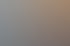 Ein heller Therapieraum mit Klangschalen, einer Behandlungsliege und einem Schreibtisch.