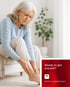 Older woman rubs her sore ankle, seeking nerve pain treatment.