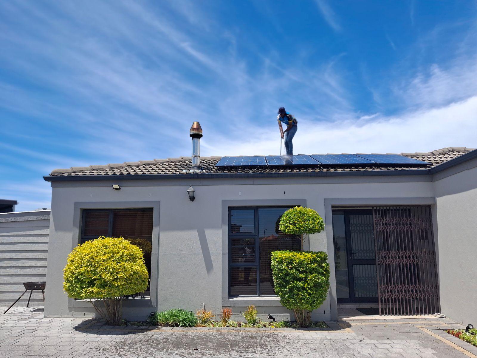 Monteur montiert ein Solarmodul auf einem Wohnhausdach