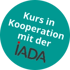 Kurs in Kooperation mit der IADA-Logo auf türkisem Kreis.