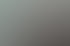Lächelnde junge Frau mit blonden Haaren sitzt am Schreibtisch im Büro vor einem Computerbildschirm.