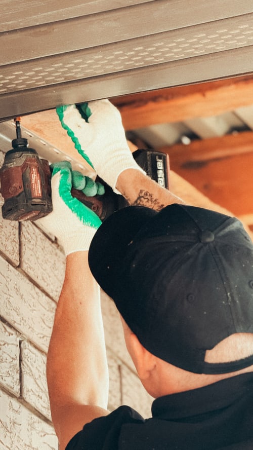 Contractor installing an outdoor light fixture
