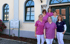 Sechs Frauen in pinken und blauen Kasacks vor einem Gebäude mit der Aufschrift "Altes Rathaus".