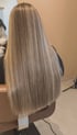 Rückansicht von langem, glattem Haar mit aschblonden Highlights und einem präzisen, geraden Schnitt.