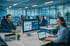 Mitarbeiter lächeln und arbeiten an Computern in einem modernen Büro mit blauen Lichtlinien.