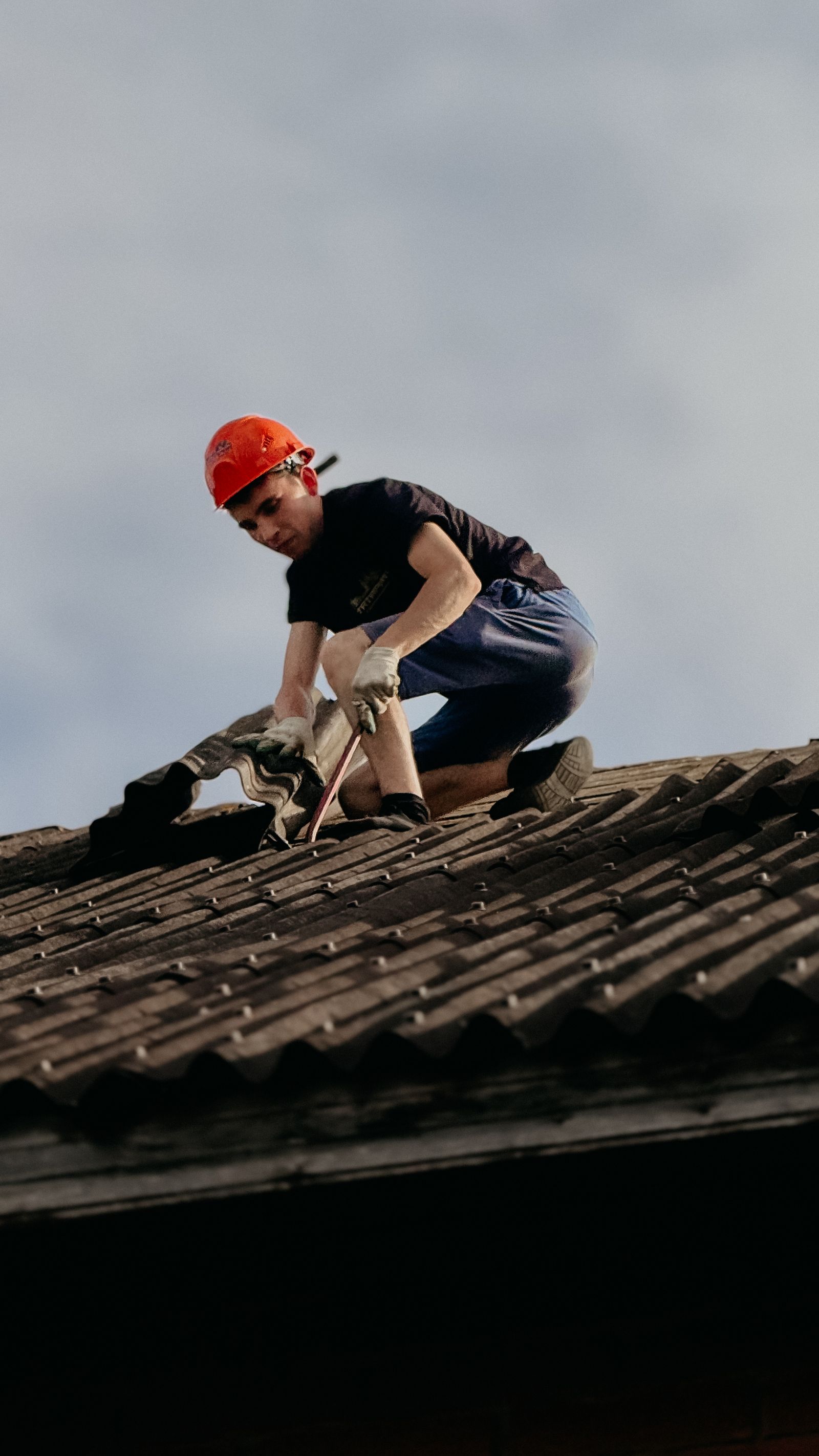 Roofer in a safety helmet carrying out a targeted roof repair