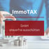Eine Person hält einen Stift über ein Modellhaus, mit den Texten "ImmoTAX" und "Stiftung gründen".