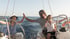 Skipper gibt high five einem kind dass das Boot steuert