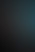 Ein Mann im Anzug hält eine Rede an einem Rednerpult vor grauem Vorhang mit roter Beleuchtung und einem blauen Bildschirm.