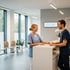 Medizinische Fachangestellte im Gespräch am Empfang einer modernen Arztpraxis