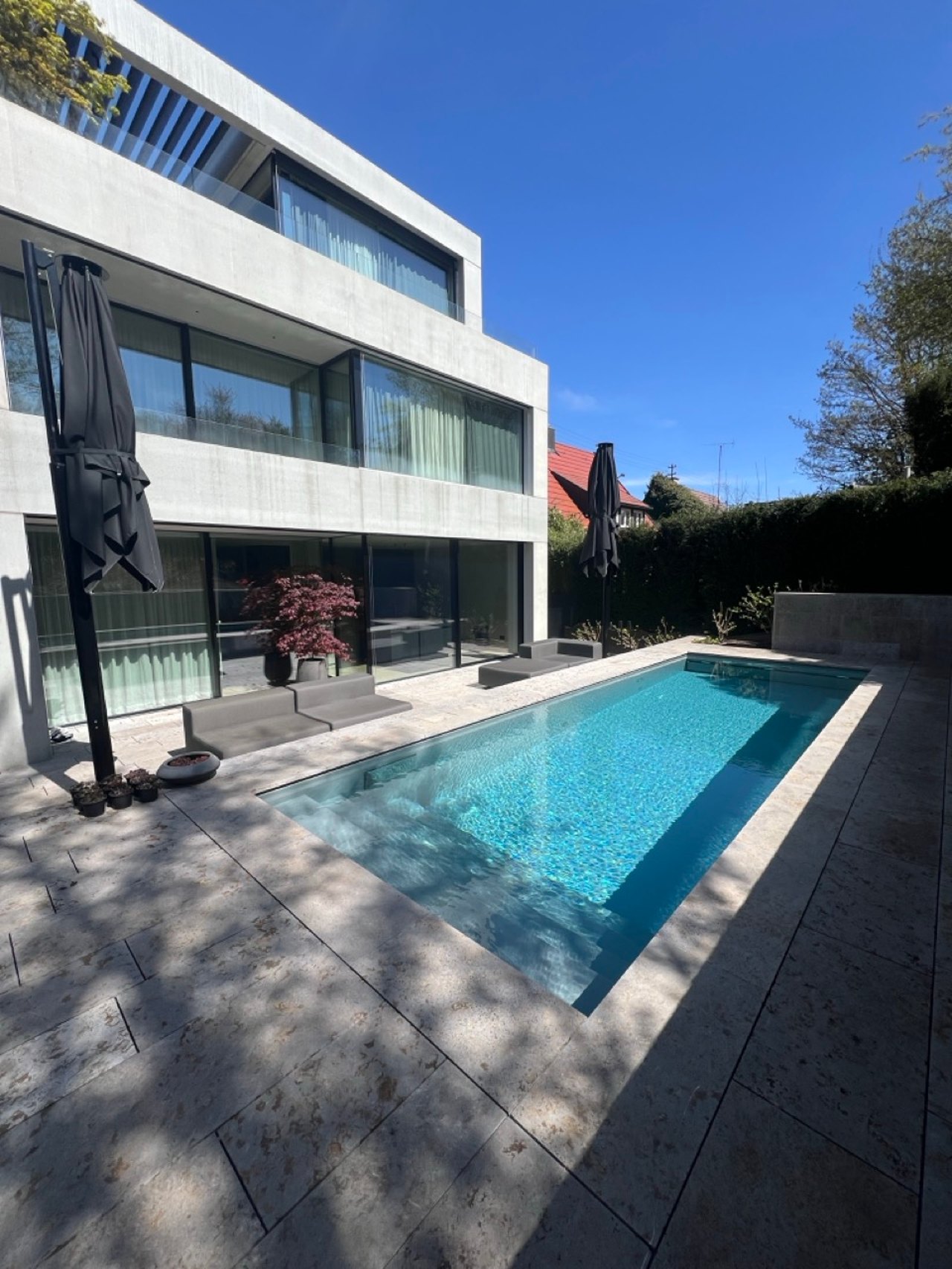 Modernes Haus mit Pool und großen Sonnenschirmen