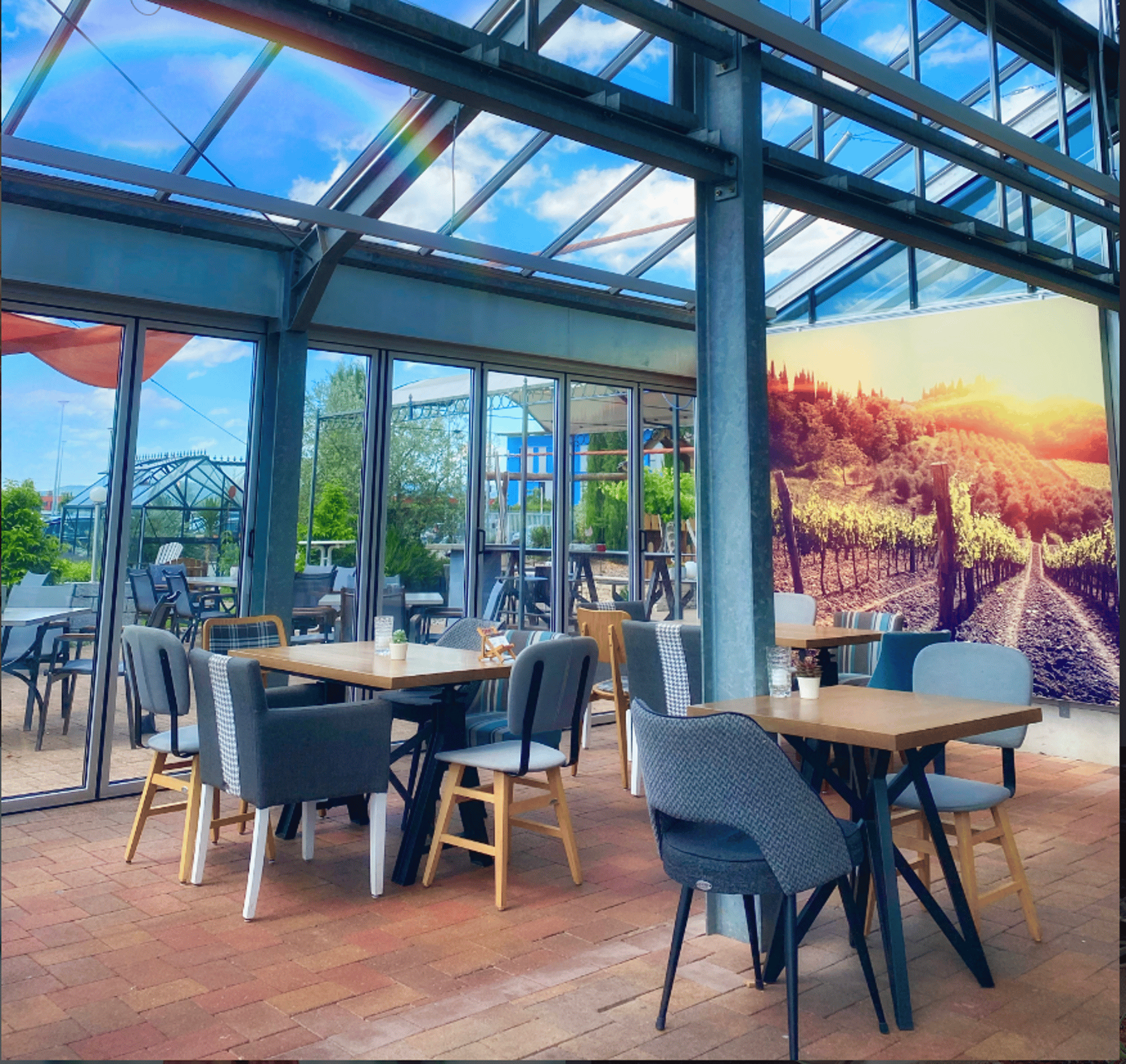 Wintergarten-Restaurant mit verglastem Dach, Holztischen und Stühlen