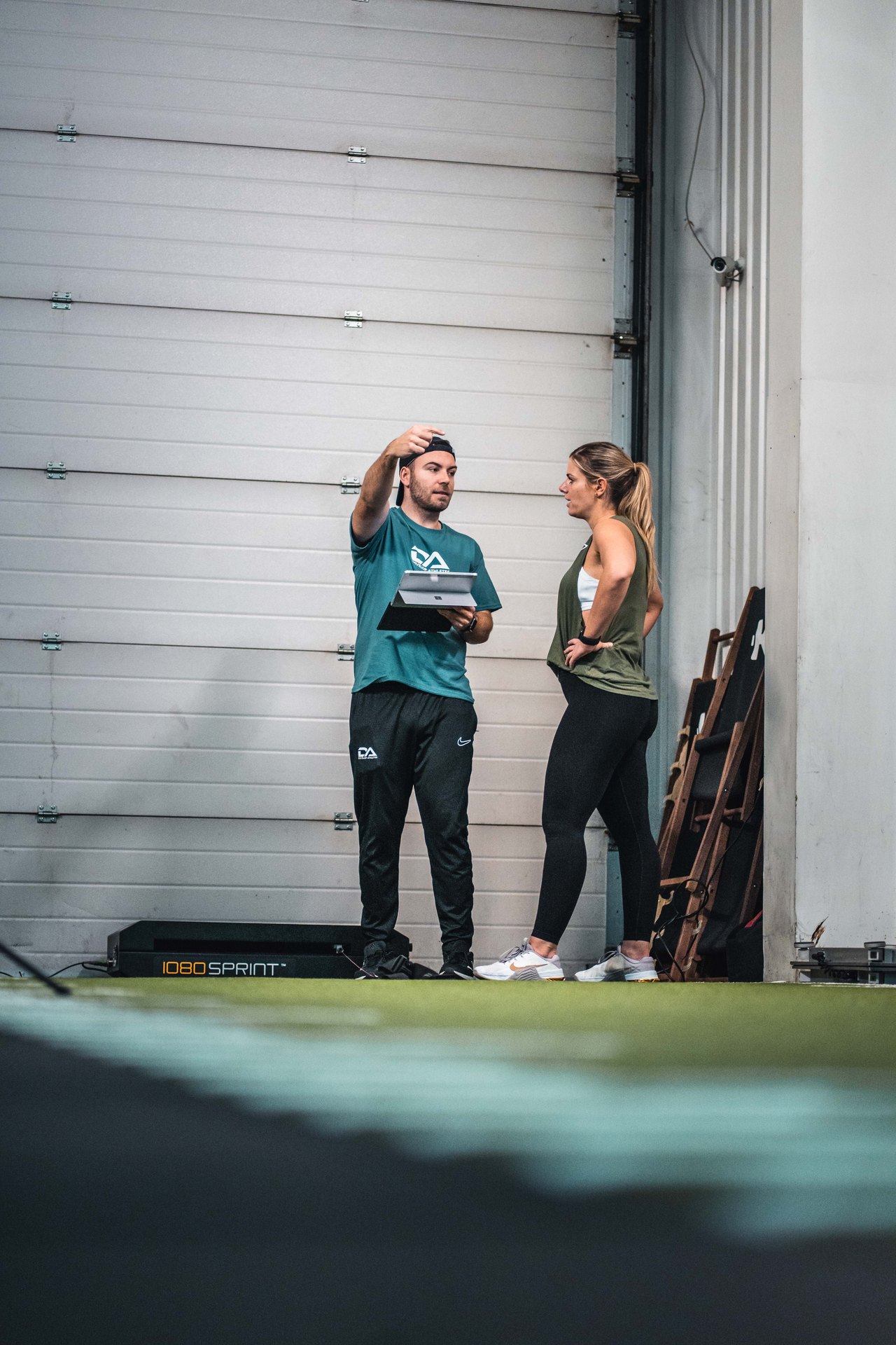 Coach erklärt einer Athletin den Test in der Krafthalle