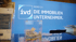 Blaues Schild mit "IVD NORD E.V. DIE IMMOBILIEN UNTERNEHMER." und eine durchsichtige Box mit Zetteln.