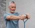 senior man uses a blue resistance band, benefiting from NAD+ therapy