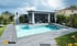 Moderner rechteckiger Pool mit Holzdeck und Lounge-Bereich, umgeben von Garten und Wohnhäusern bei bewölktem Himmel.