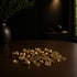Haufen goldener Nuggets, Goldzähne und quadratischer Goldplatten auf einem Holztisch.