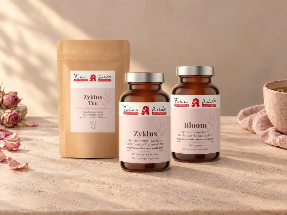 EVIORA Zyklus-Tee, Zyklus und Bloom auf zartrosa Stein mit getrockneten Rosen und einer Tasse Tee
