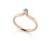 Ein schmaler Verlobungsring aus Roségold mit einem einzelnen, rund geschliffenen Diamanten in einer Zargenfassung.