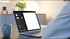Person arbeitet an einem Laptop mit leerem Bildschirm und Design-Software; Tasse daneben auf dem Schreibtisch.