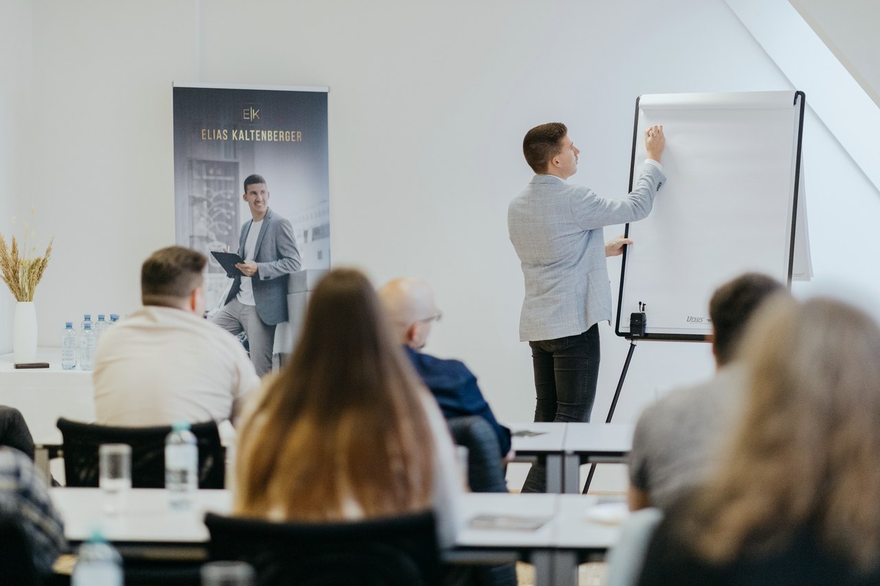 Workshop-Moment: Referent am Flipchart vor Teilnehmenden – Eventfotografie