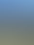 Oberkörperfreier Mann steht auf einem Felsen vor einer großen Bergkulisse unter blauem Himmel.