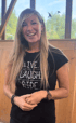 Lachende Frau mit langen blonden Haaren trägt ein schwarzes T-Shirt mit der Aufschrift „LIVE. LAUGH. RIDE.“