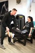 Trainer hilft Frau an Beinpresse im Fitnessstudio mit Technogym-Gerät.