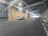 Weißer Lieferwagen parkt in einer im Bau befindlichen Tiefgarage mit freiliegenden Lüftungsrohren und Holzverkleidungen.