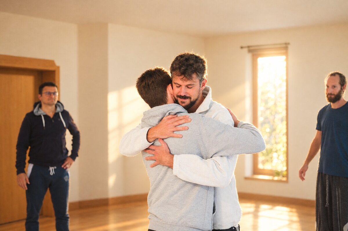Moritz Ertinger umarmt einen Teilnehmer bei einem Workshop.
