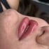 Nahaufnahme der Lippen einer Person nach einer Permanent-Make-up-Behandlung, die rosafarbenen Lippen sind geschwollen.