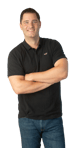 Ein lächelnder Mann in einem schwarzen Poloshirt und Jeans steht mit verschränkten Armen.
