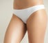 Nahaufnahme der Hüften und Oberschenkel einer Person, die einen einfachen weißen Tanga trägt.