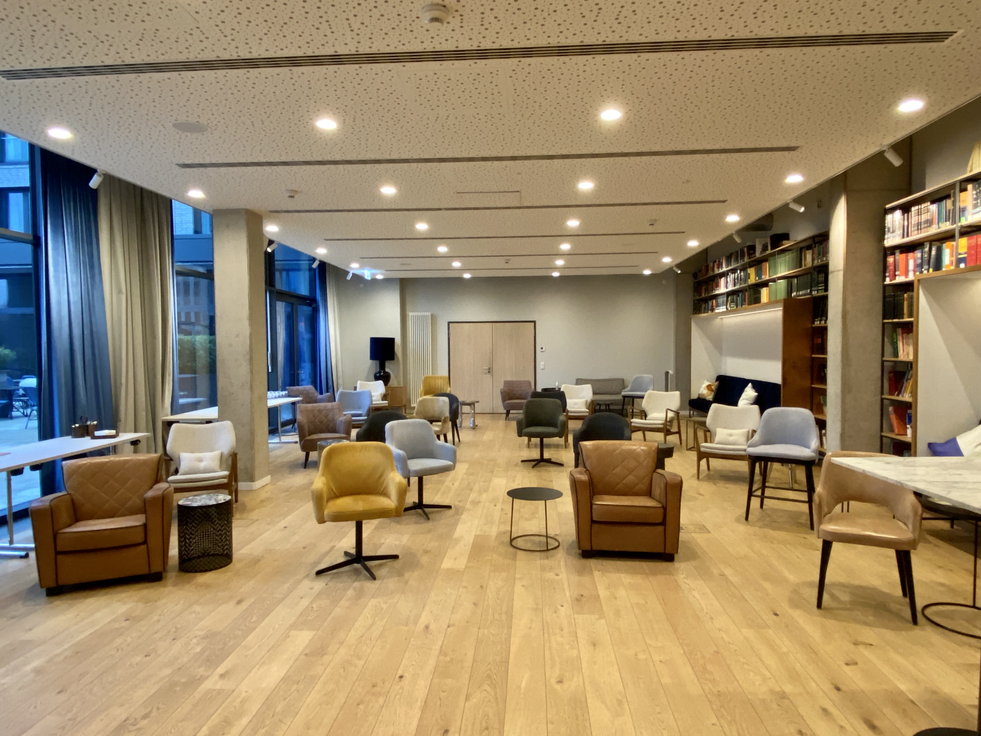 FREIgeist Göttingen Innenstadt – Lounge- und Bibliotheksbereich mit Holzboden und Sitzmöbeln