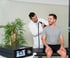 Smiling man receiving shoulder treatment from a Gainswave therapist using a handheld device.