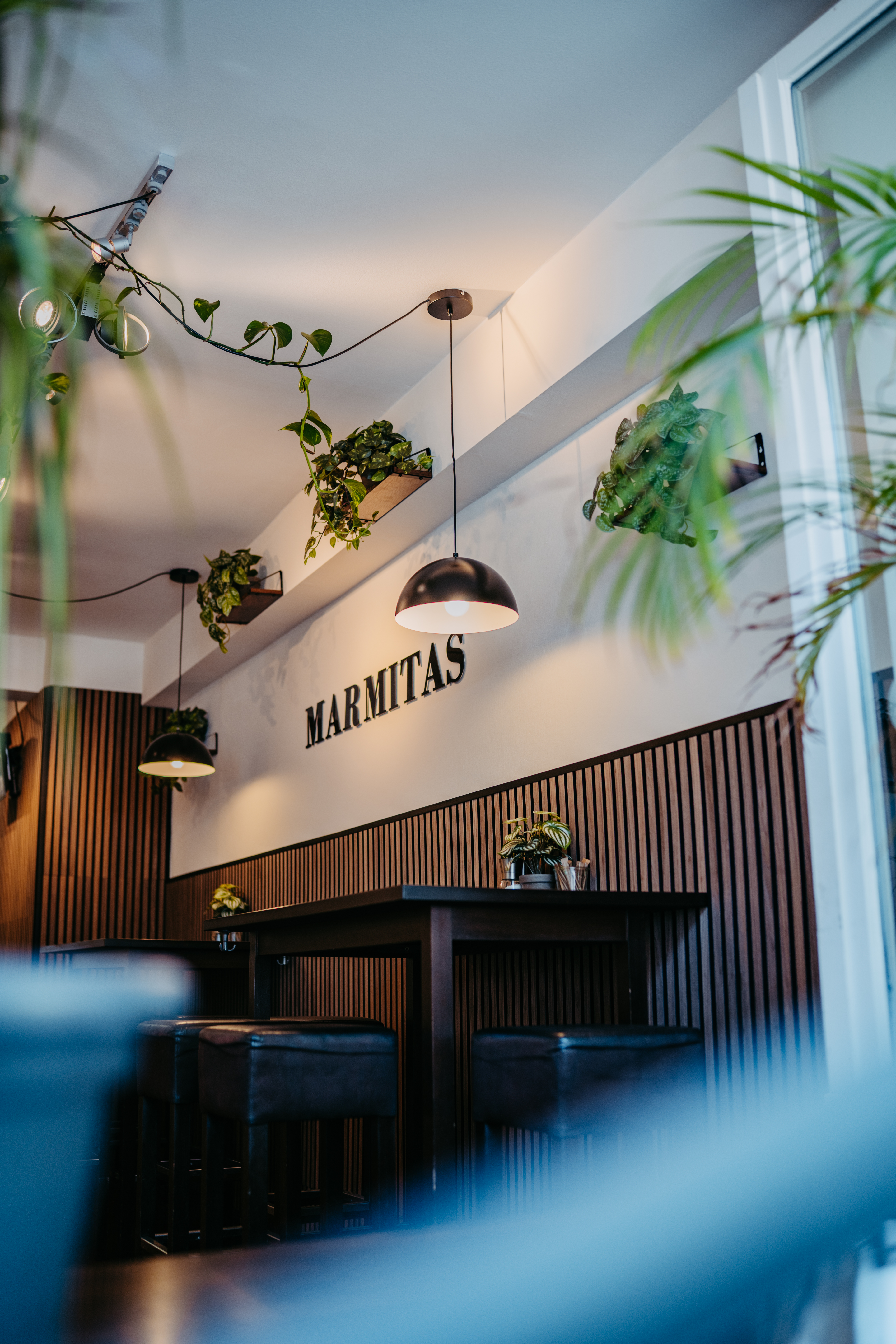 Gastraum eines Marmitas Stores mit Schriftzug an der Wand und Holzvertäfelung
