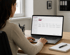 Eine Frau arbeitet am Laptop an einem Schreibtisch und nutzt eine Softwareoberfläche zur Kontaktverwaltung - Software für Alarmierung - Notfall- und Krisenmanager (NKM®).