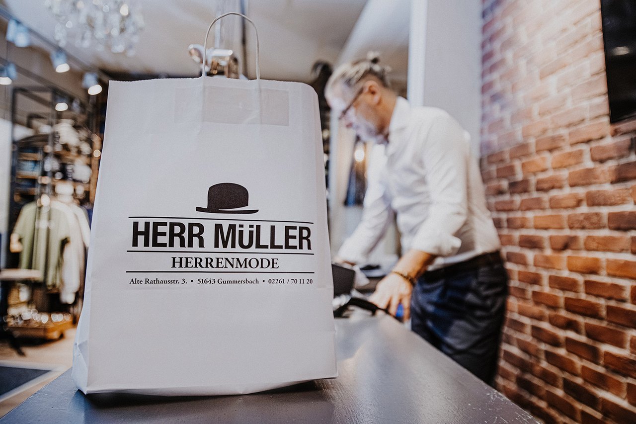 Einkaufstüte mit Herr-Müller-Logo auf der Ladentheke