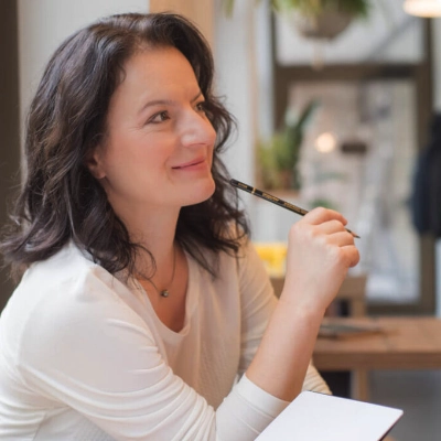 Texterin sitzt am Schreibtisch und denkt nach