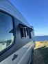 Detailaufnahme Camperfenster mit Ausstellfunktion – perfektes Lüftungssystem für Wohnmobile am Meer