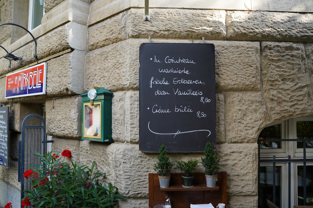 Eingang mit Kreidetafel und Blumen