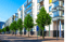 Reihe moderner Wohngebäude mit Glasbalkonen und Bäumen entlang einer Straße mit Parkschild "P".