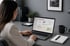 Frau arbeitet am Laptop mit geöffneter Webseite "Willkommen, Max!" - Software-KRITIS Notfall- und Krisenmanager (NKM®).