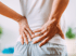 Person clutching their back for sciatica and nerve pain relief