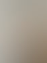 Junge Frau mit blonden Haaren und weißem Oberteil, die mit verschränkten Armen lächelt.