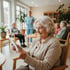 Lächelnde Seniorin im Videocall mit ihrer Familie über stabiles WLAN in einer modernen Pflegeeinrichtung