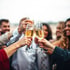 Gruppe von Menschen stößt mit gefüllten Champagnergläsern an.
