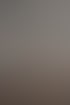 Ein Physiotherapeut behandelt einen Patienten auf einer Liege in einem Fitnessstudio mit einem perkussiven Massagegerät.