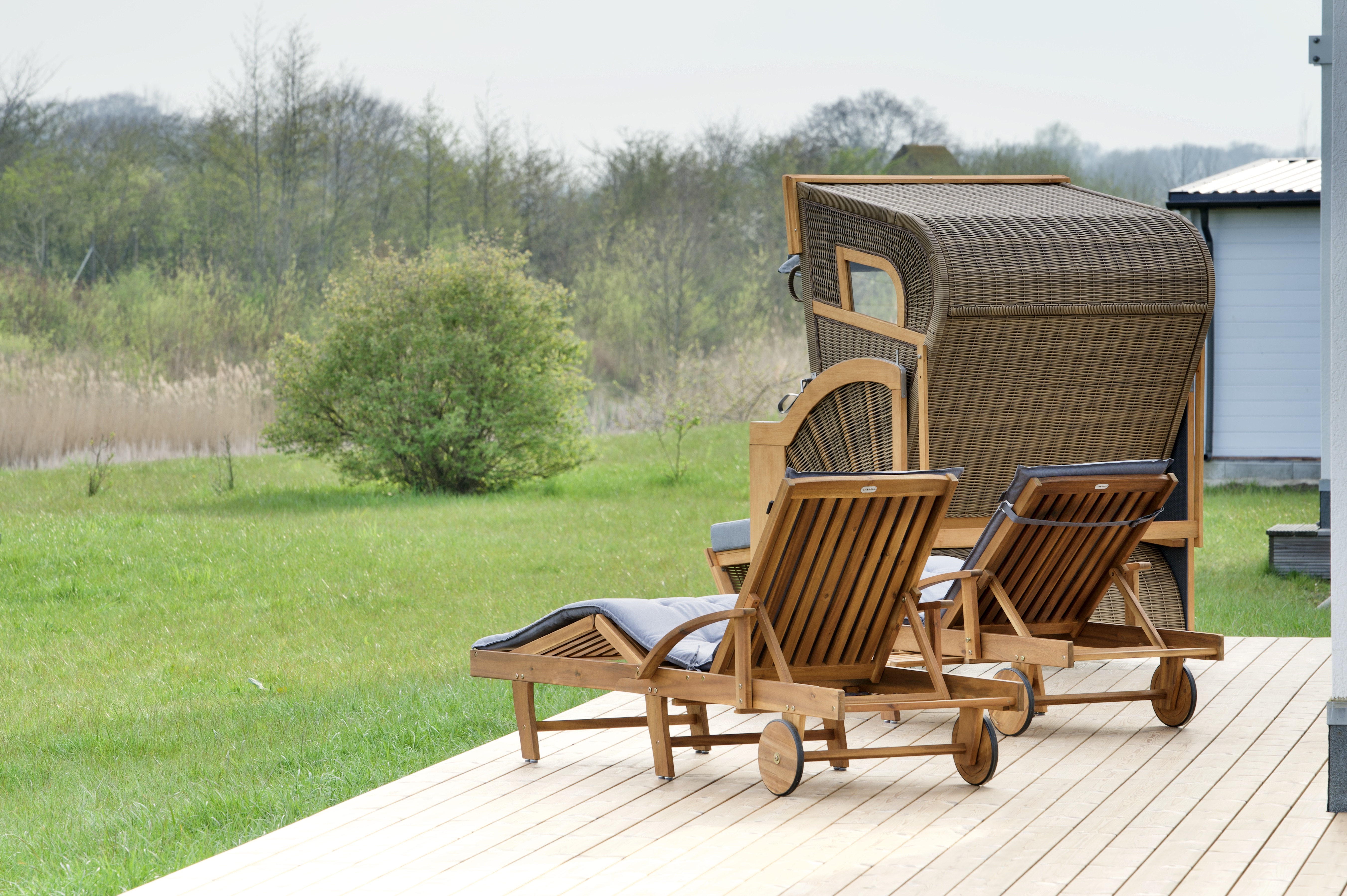 Skipper Galerie im OstseeResort Olpenitz – Holzterrasse mit Liegen und Strandkorb im Außenbereich